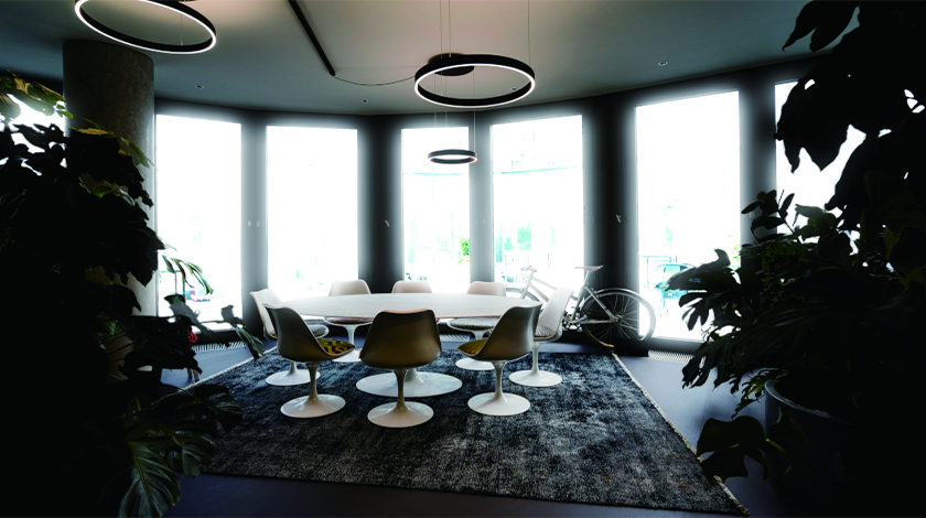 比較画像：商談スペース、いくつもの大きな窓、大きなテーブルと8つの椅子左：窓の外が逆光で見えない