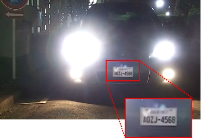 比較画像：夜間、車のヘッドライトが点灯している中でのナンバープレート