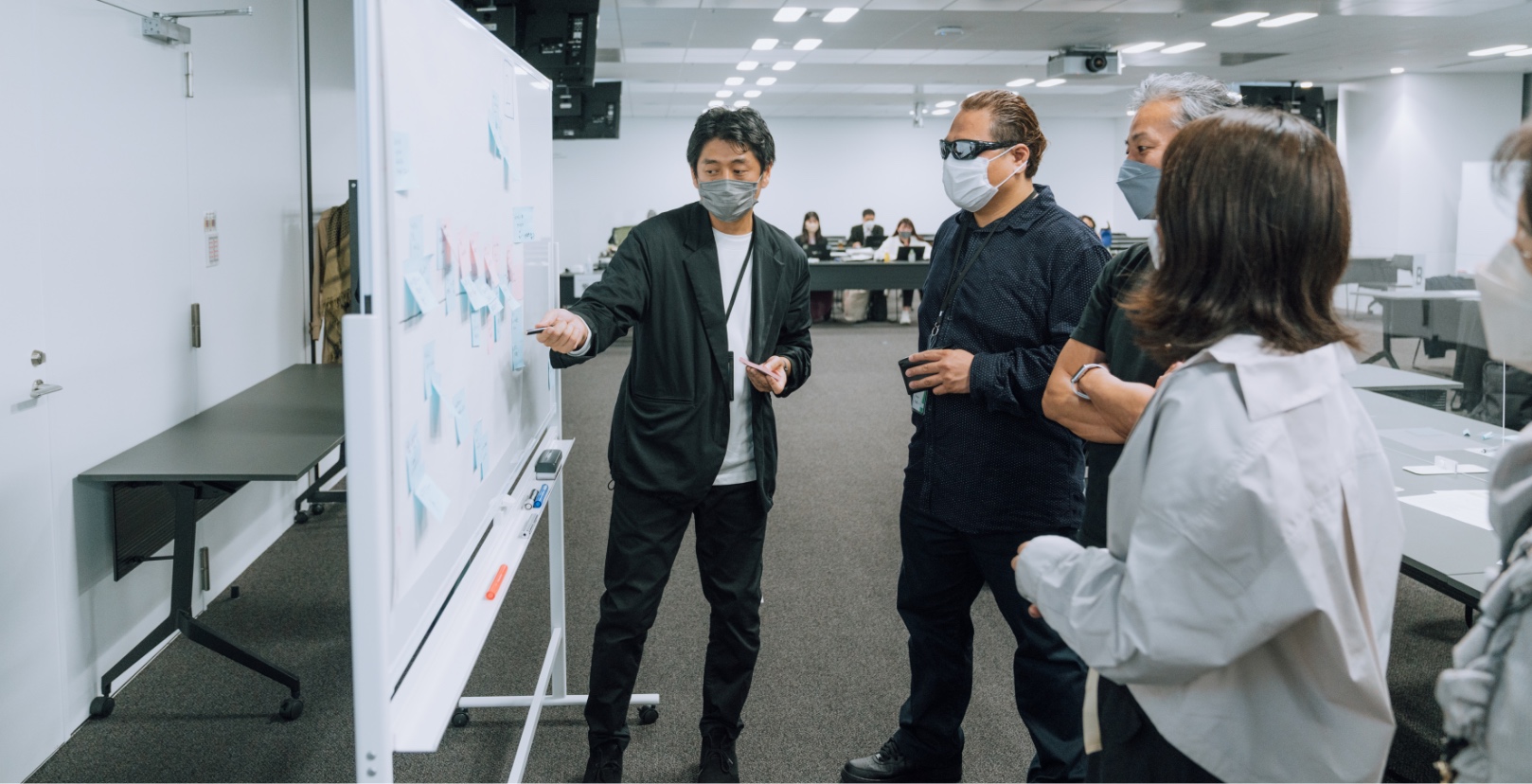ソニー株式会社(SEC)の社員5人と佐藤さんがホワイトボードを見ている写真