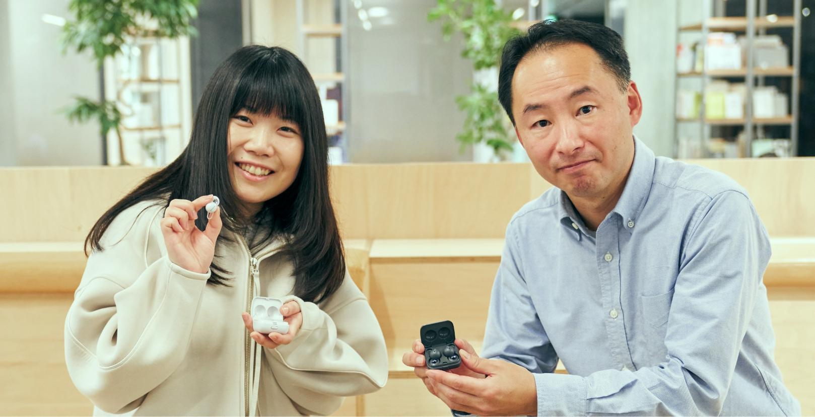 三木晴子さんと田中光謙さんがベンチに座りカメラに向かってLinkBudsを見せている
