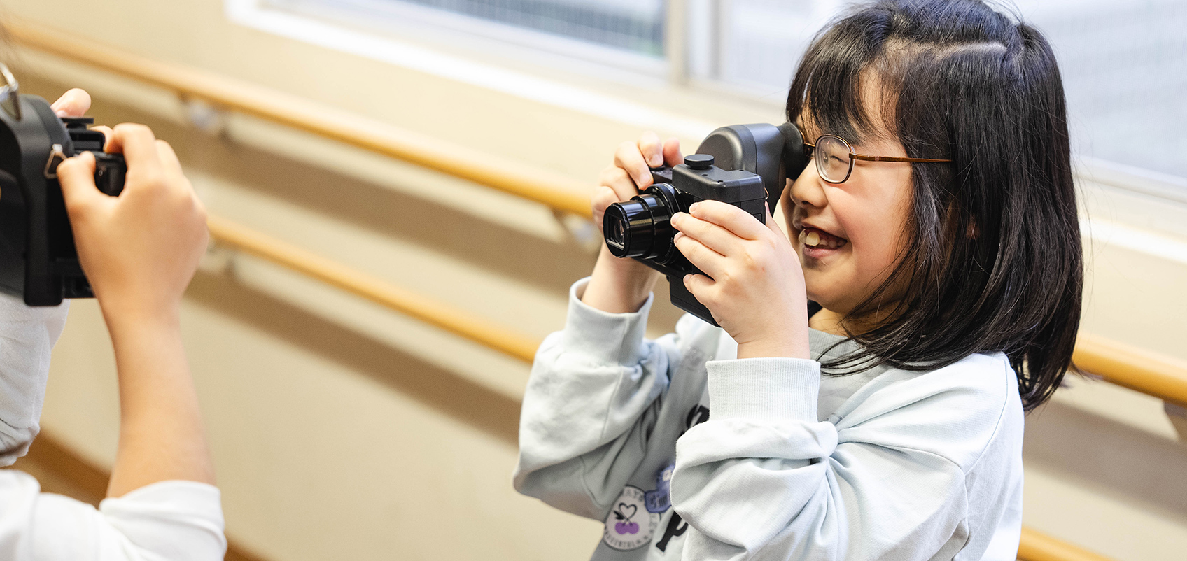 子供同士で寄贈された網膜投影カメラキット『DSC-HX99 RNV kit』で撮影を楽しんでいる。