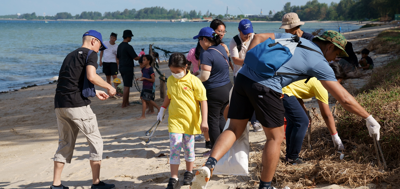 社員が子どもたちと一緒に海岸で清掃活動をしている