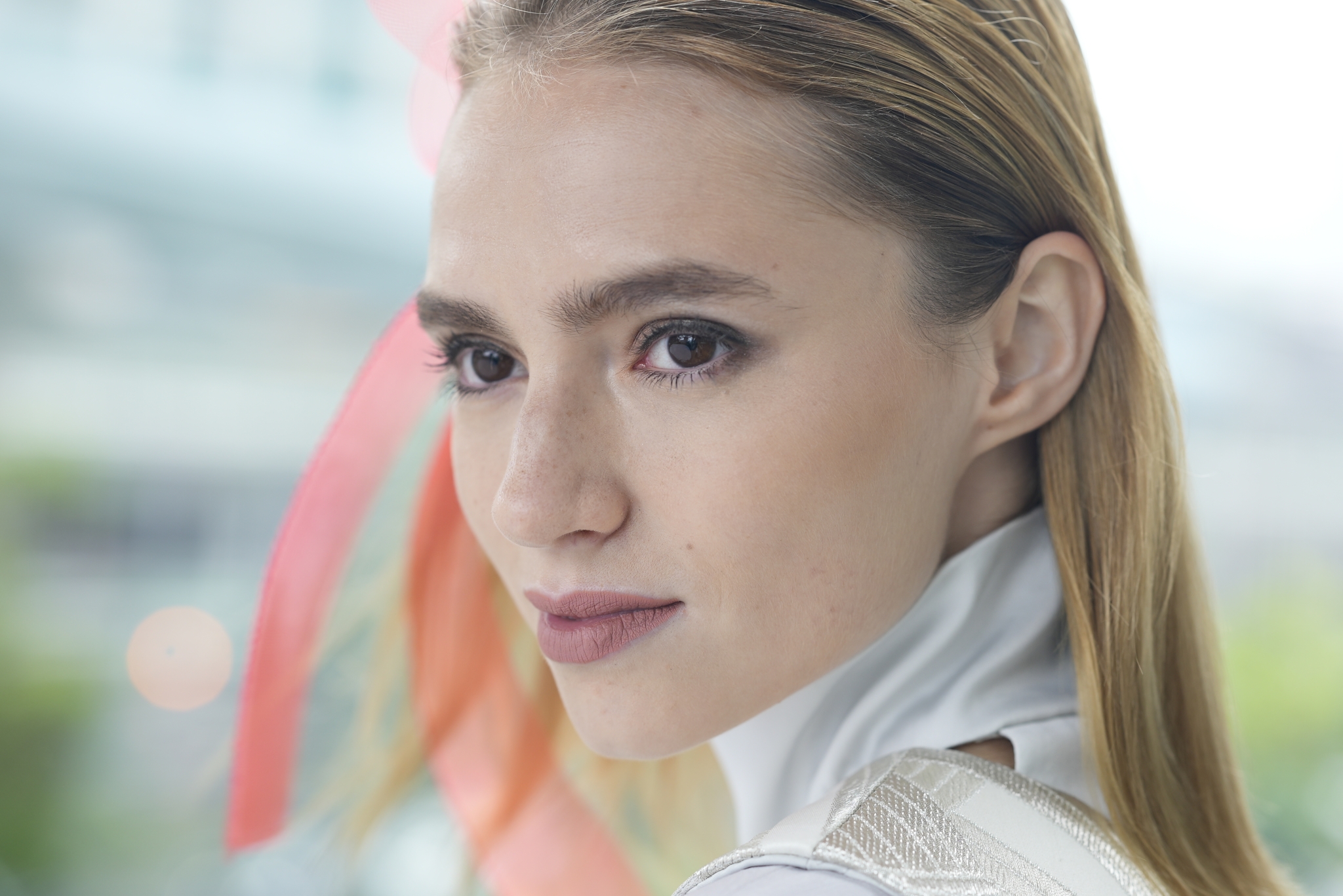 Portrait of female model with ribbon in her hair Click to open modal