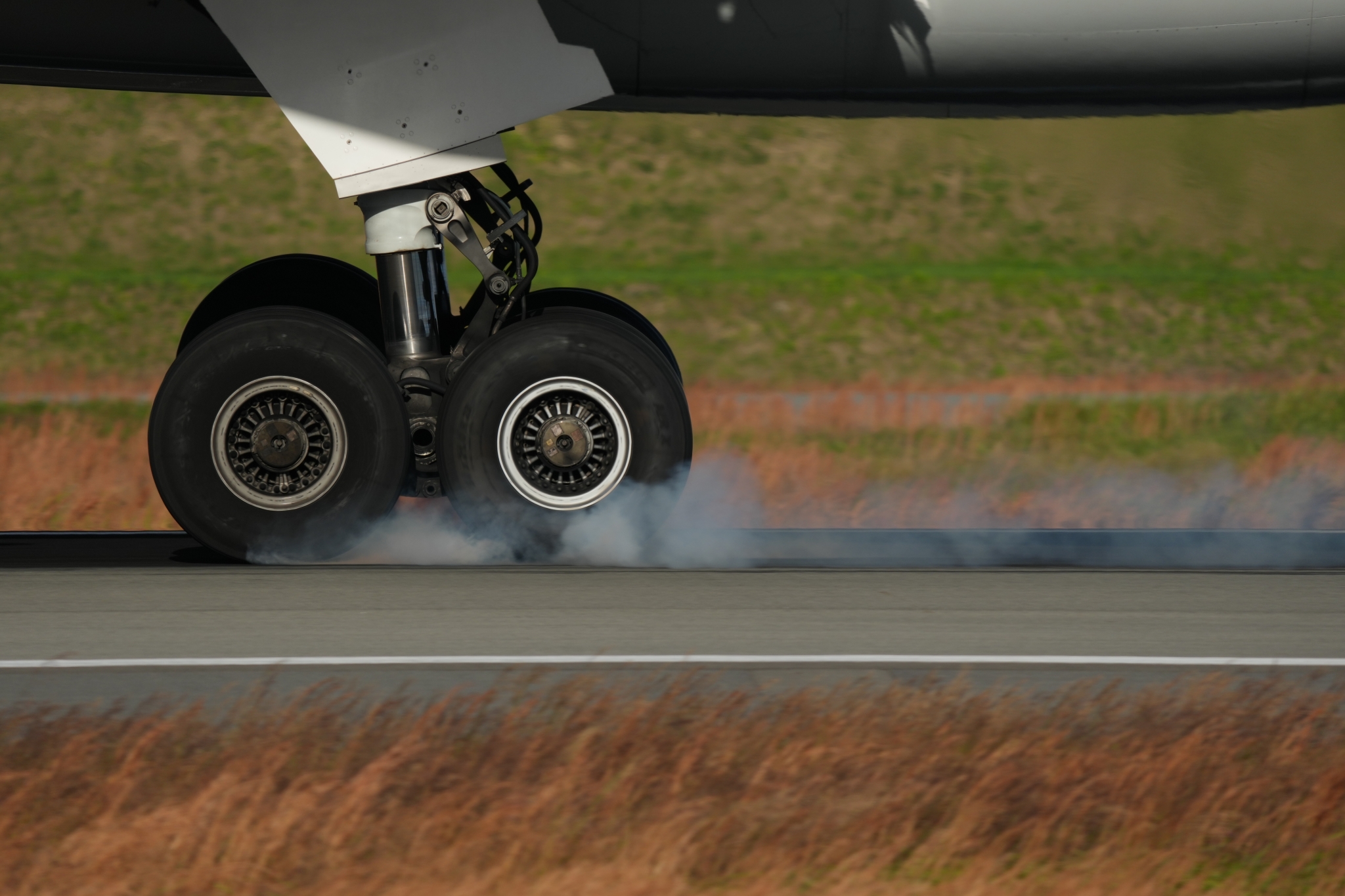 Example image showing an airplane tire touching down on the runway, creating a burst of smoke upon landing.  Click to open modal
