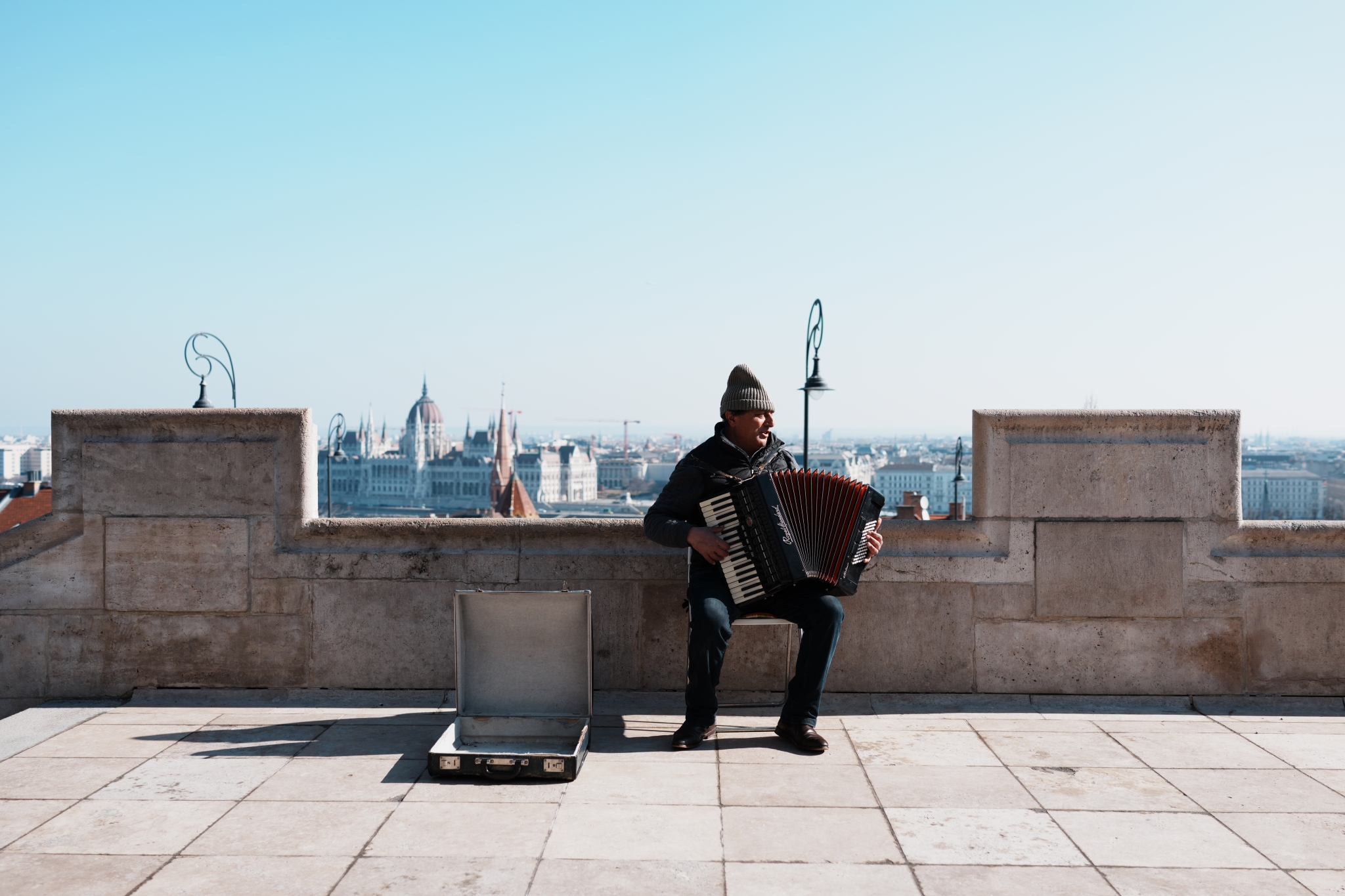 A sample image of a man playing an instrument at the street, taken in Creative Look FL mode. Click to open modal