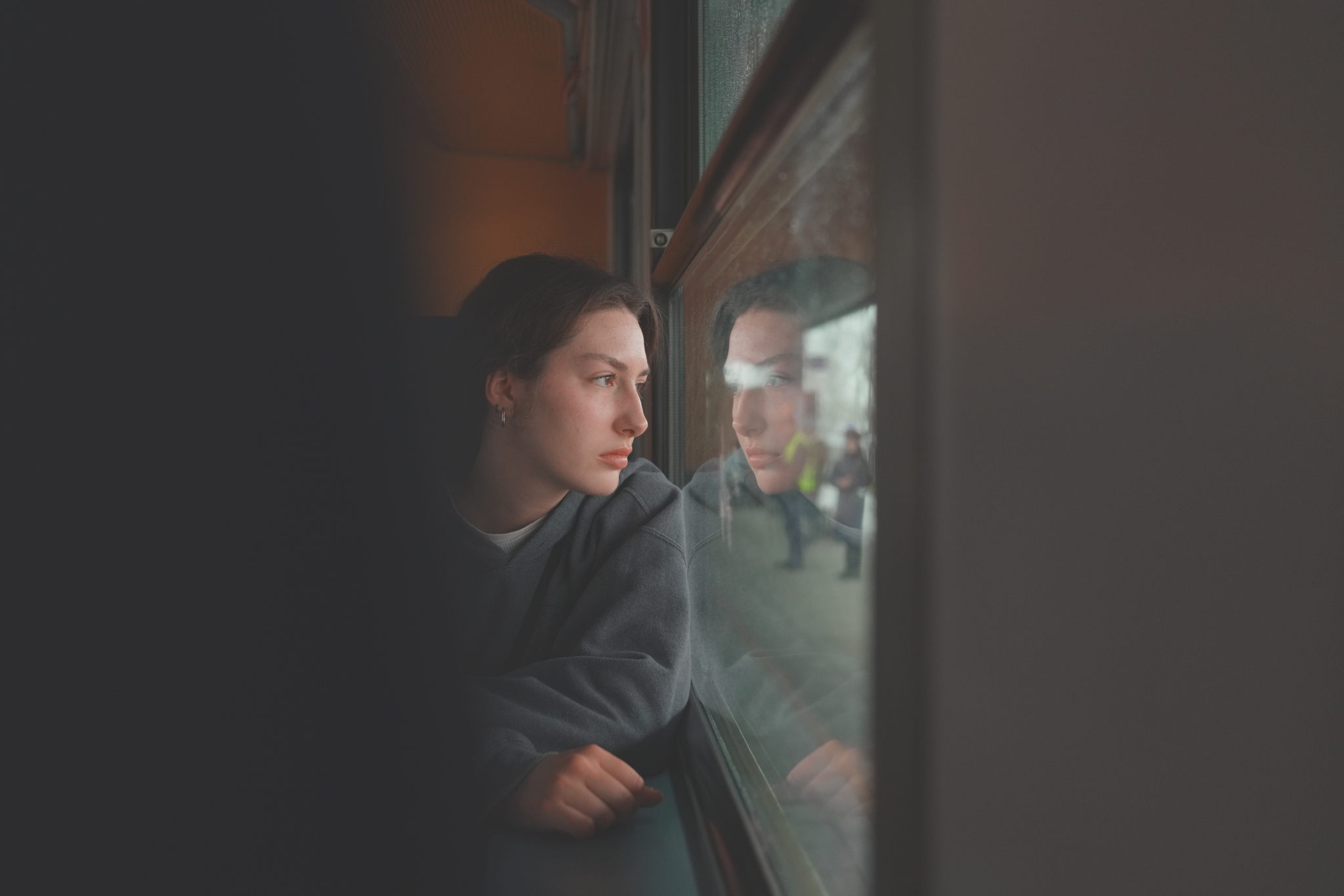 A sample image of a lady looking outside of the window, taken in Creative Look SH mode. Click to open modal