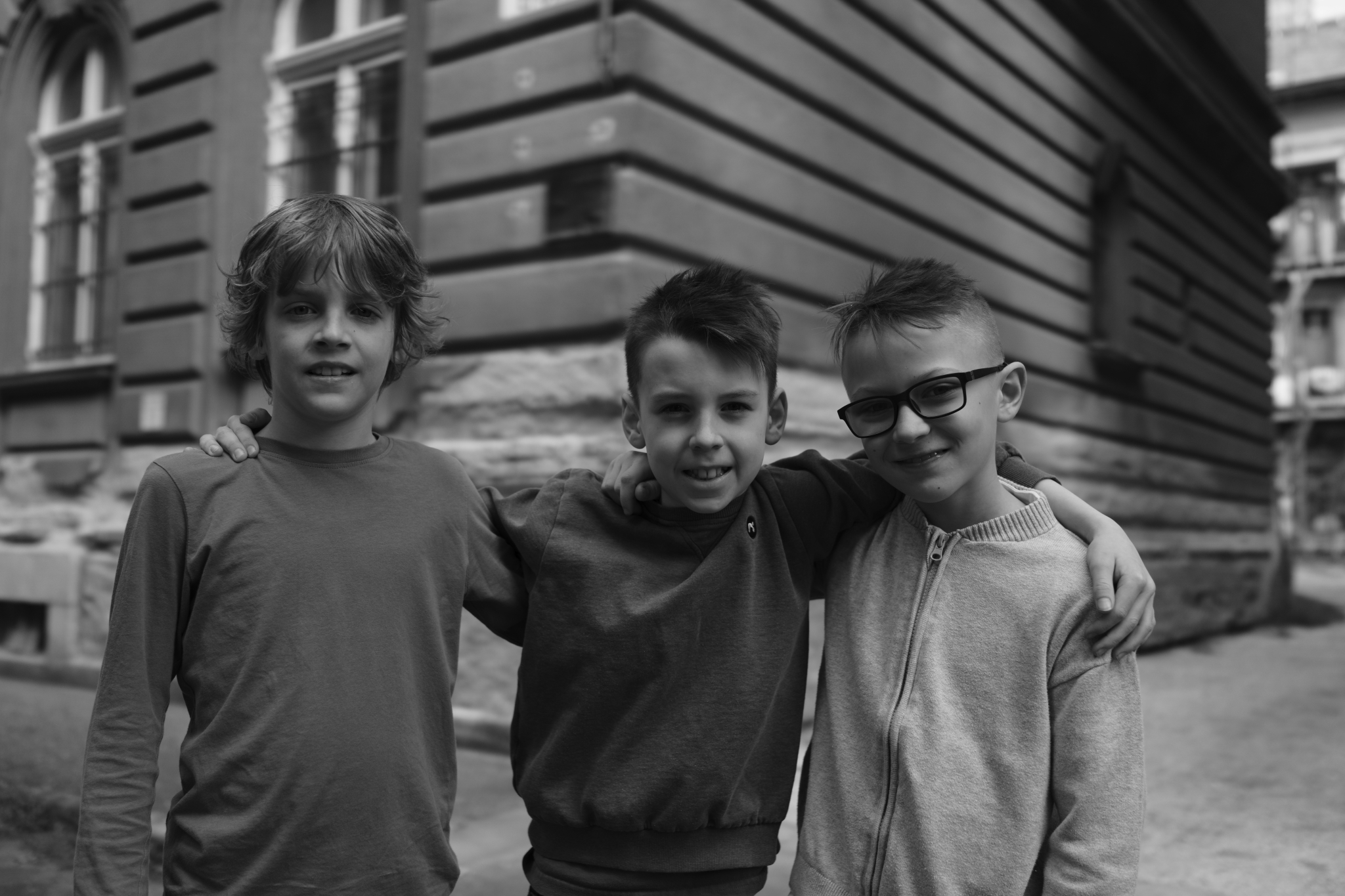 A sample image of three boys standing side by side taken in creative look BW mode. Click to open modal