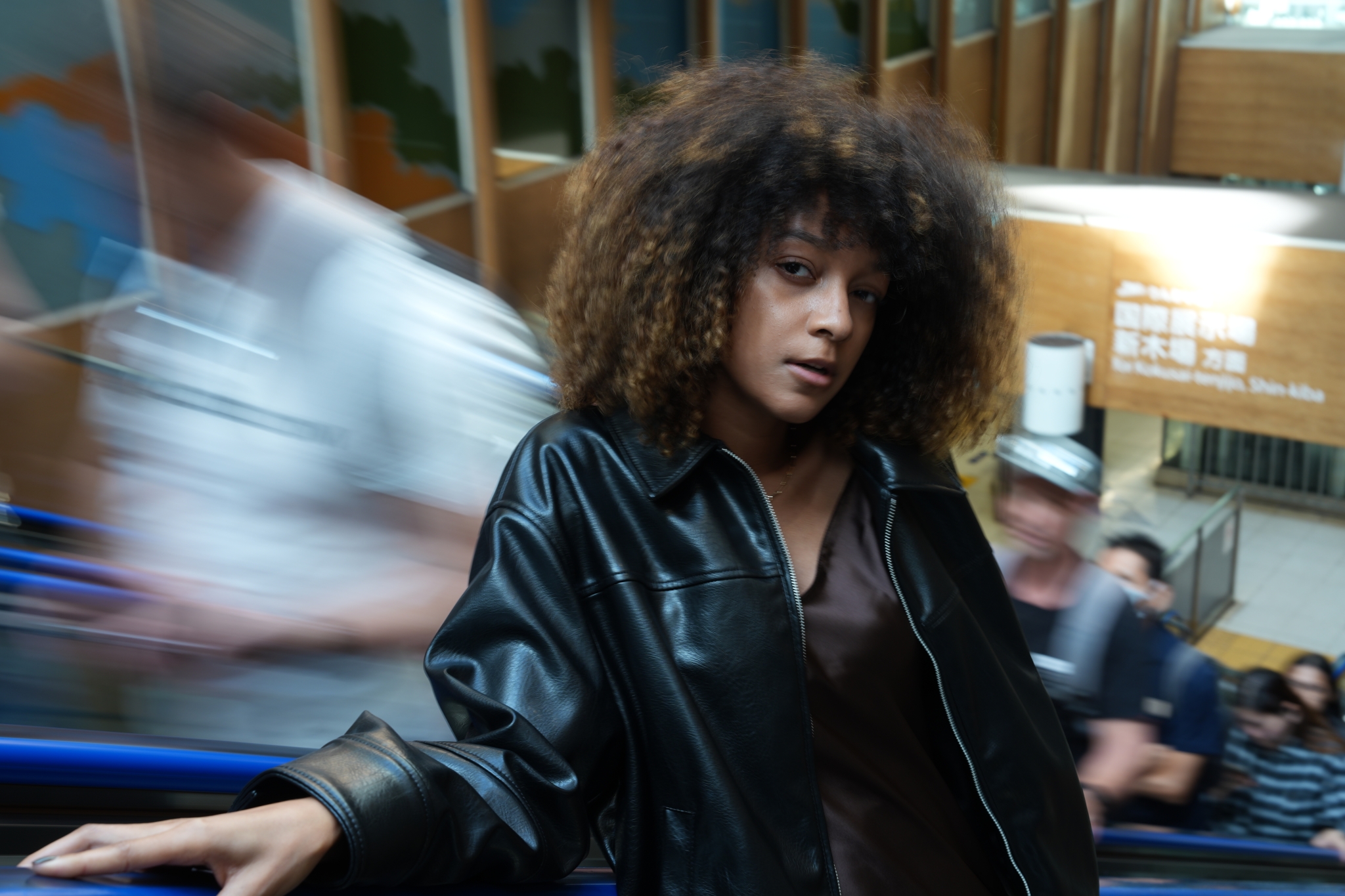 A woman riding an escalator Click to open modal