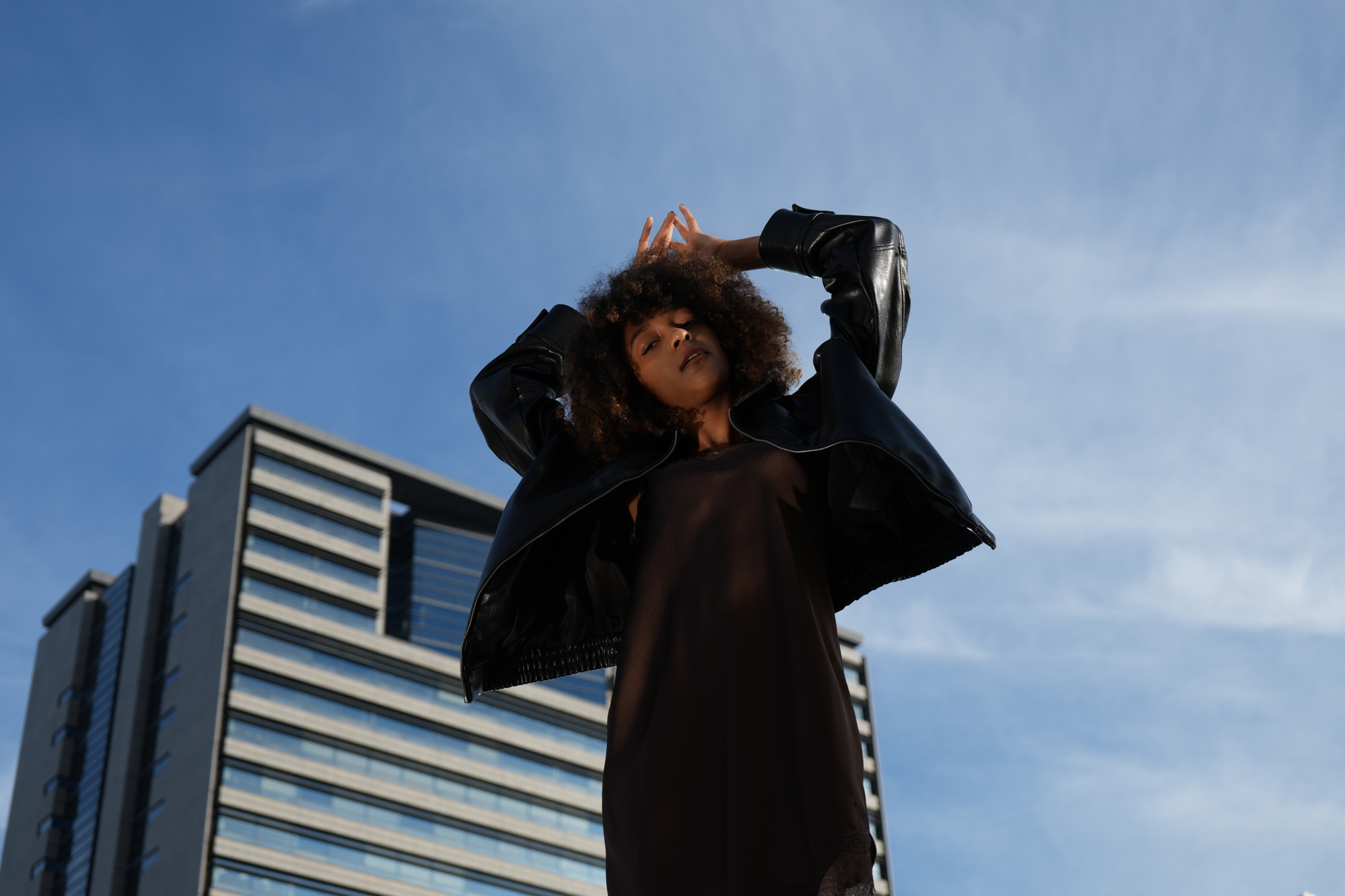 A portrait of a woman with blue sky in the background Click to open modal