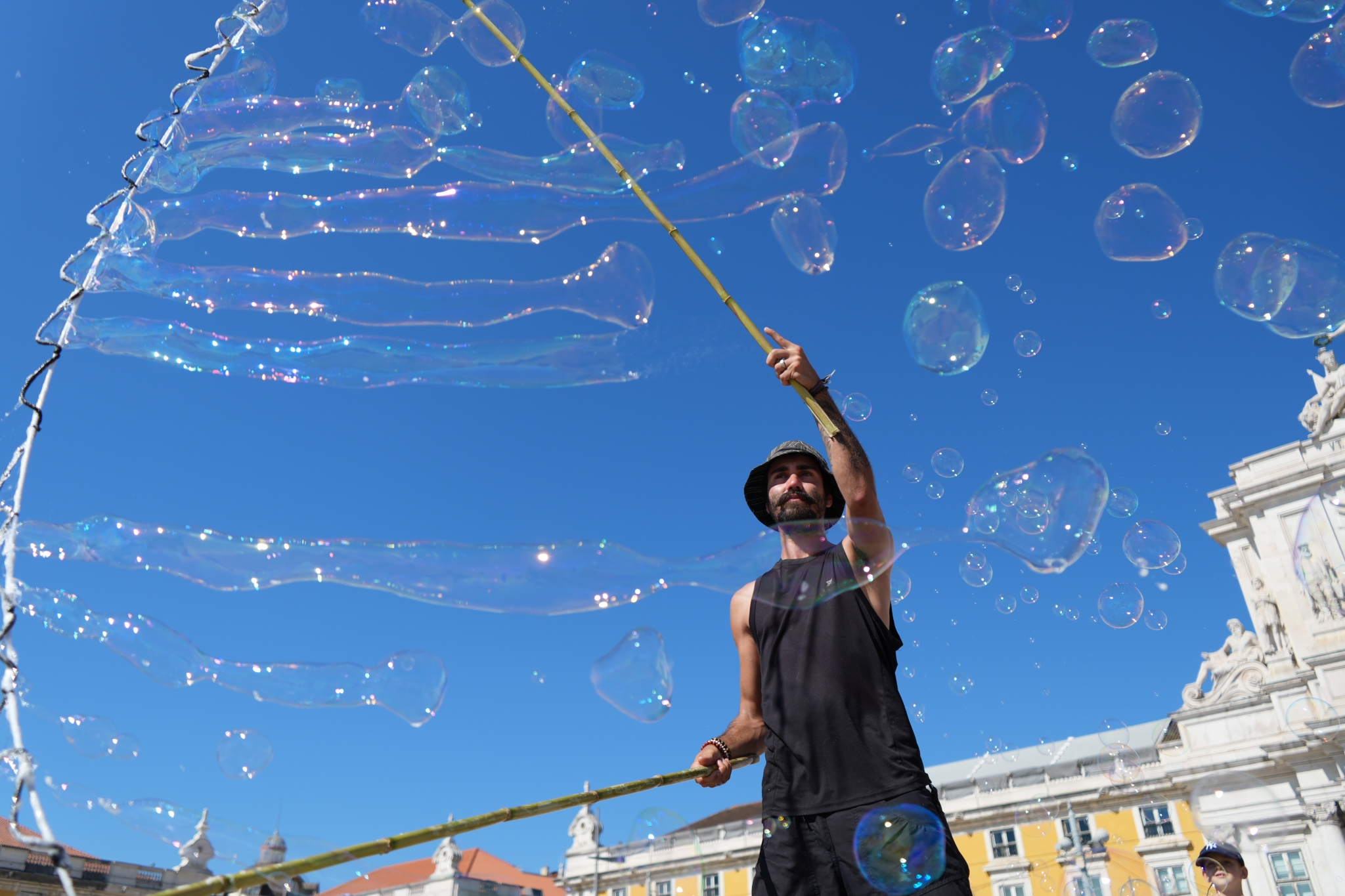 A man performing street art with soap bubbles Click to open modal