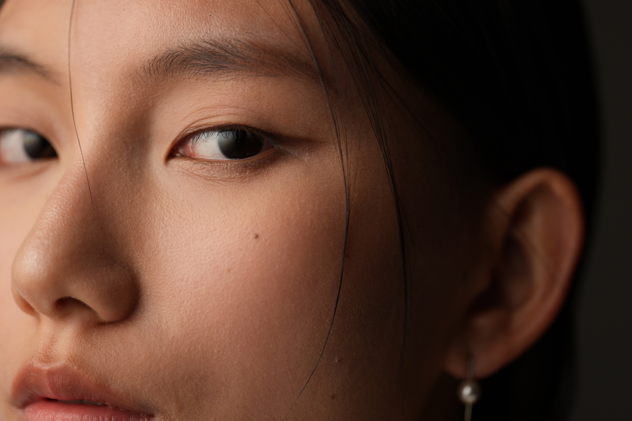 A close-up side profile of a woman with makeup applied to her eyes and cheeks Click to open modal