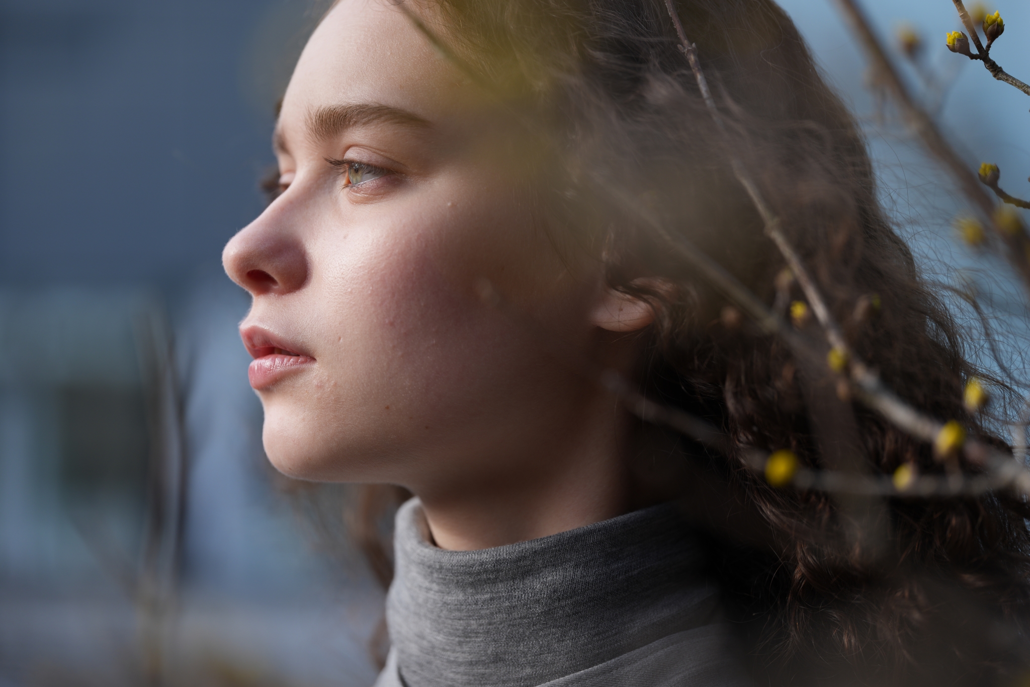 A portrait of a woman standing in front of branches with yellow fruit Click to open modal