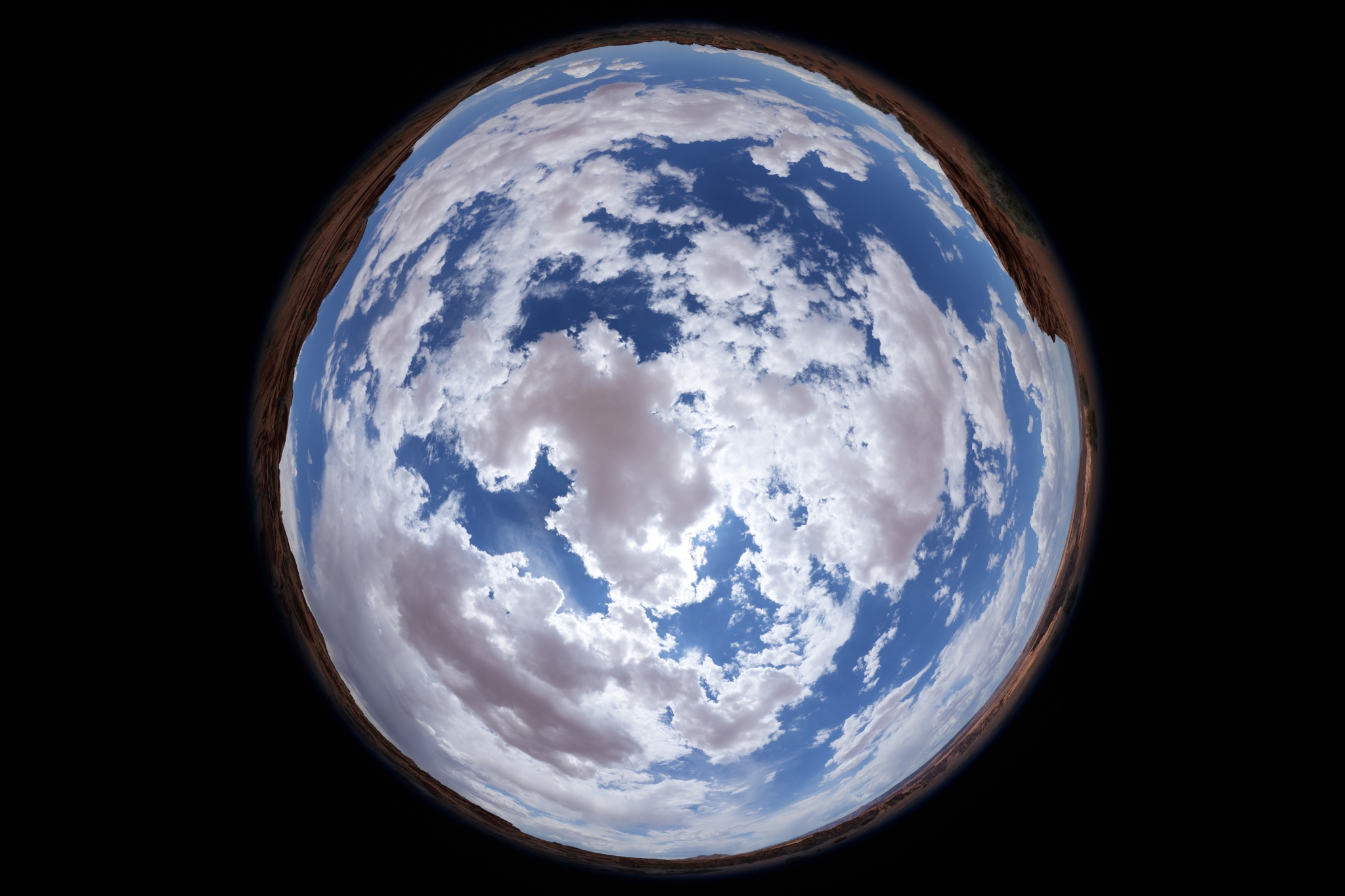 Sky photographed from below looking upward with fisheye lens, showing Earth and clouds in spherical view Click to open modal