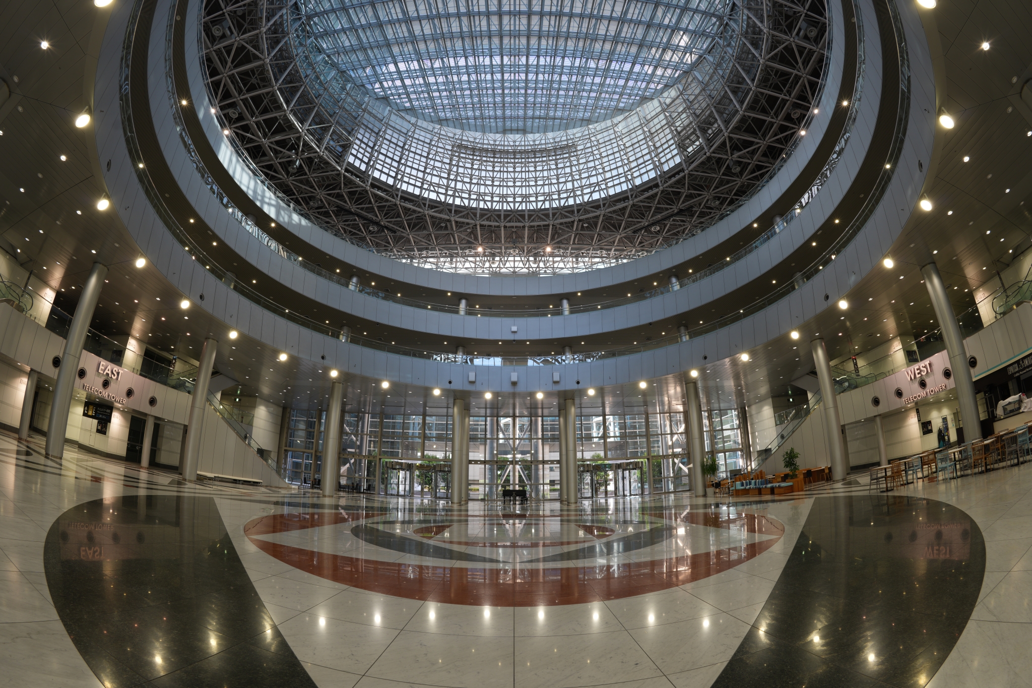 Interior view of ornate domed ceiling with concentric circular architectural rings, decorative lighting viewed from below Click to open modal