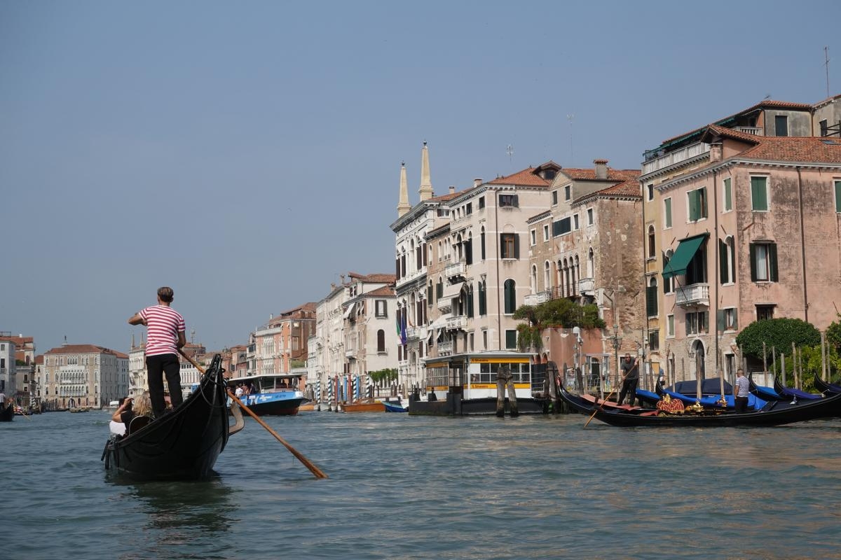 Venetian canal shot with gondola and gondolier Click to open modal