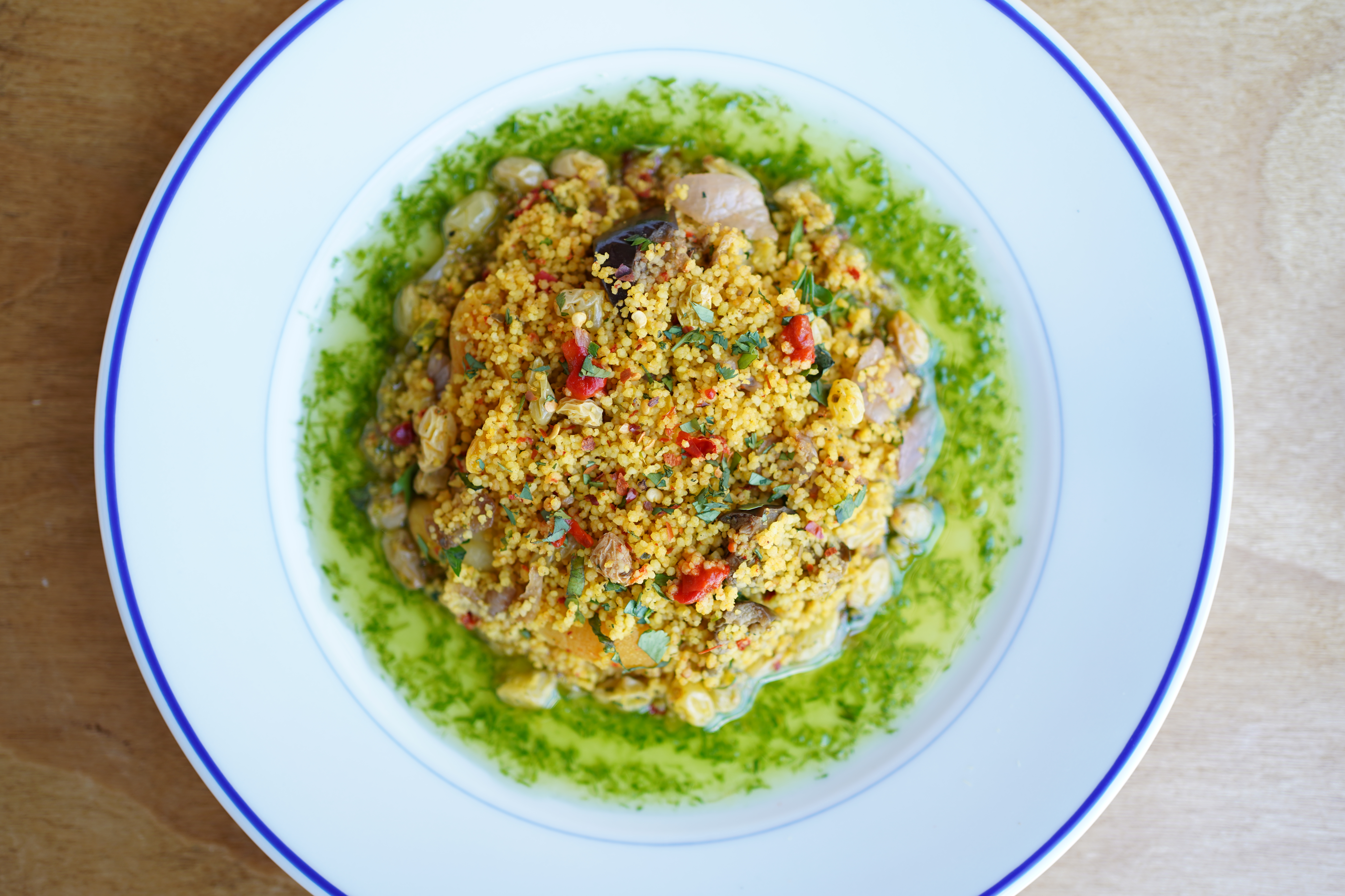 Colourful food in a green sauce arranged on a plate