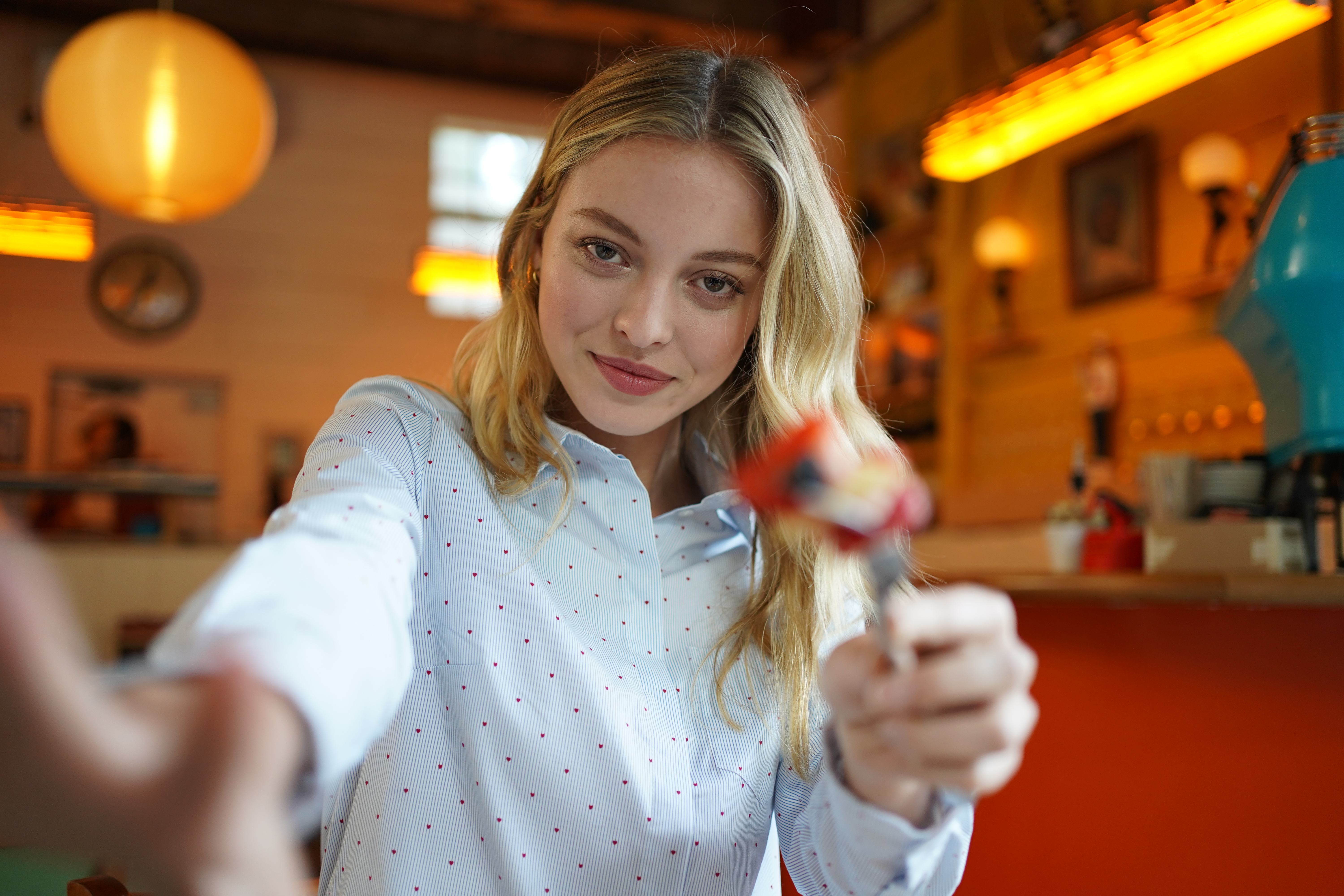 Female model holding a peace sign towards the camera