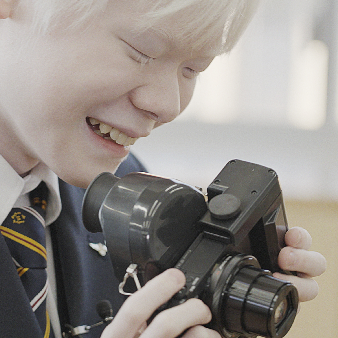 The boy is having fun touching the camera.
